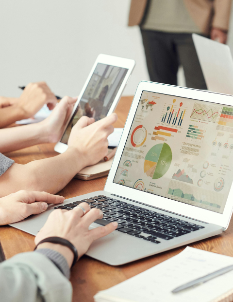 Osoba pracująca na laptopie w biurze, analizująca dane finansowe.