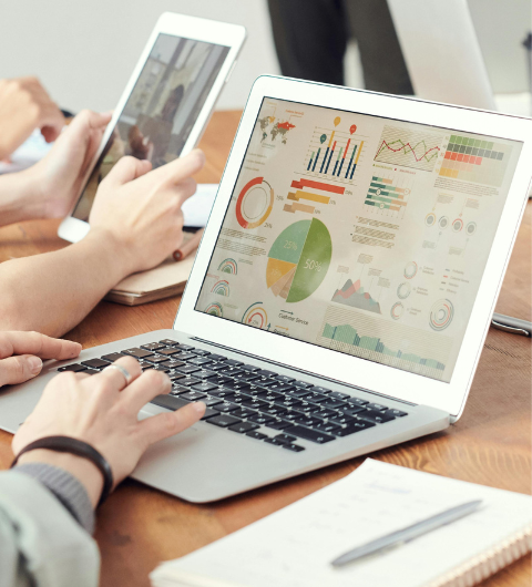 Osoba pracująca na laptopie w biurze, analizująca dane finansowe.